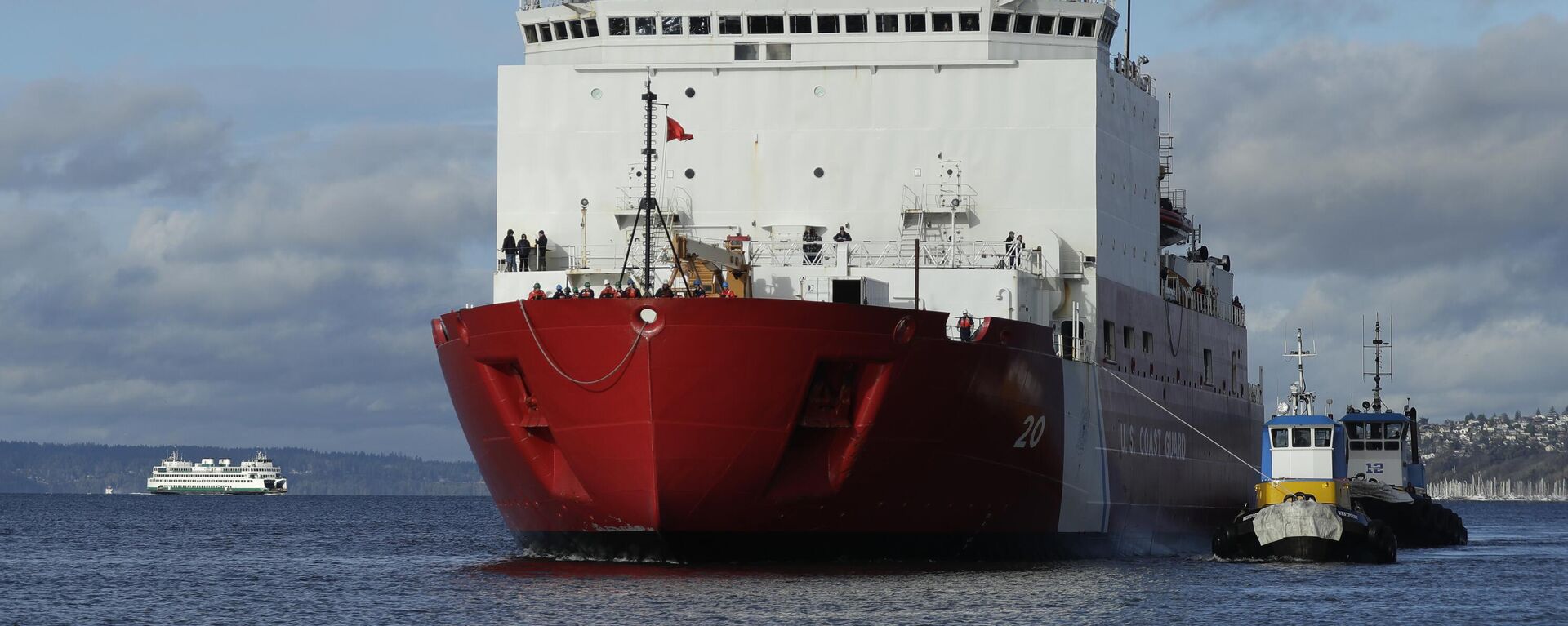 In this Nov. 30, 2018, file photo tugboats help the US Coast Guard Cutter Healy icebreaker into her homeport of Seattle, as a Washington state ferry passes in the background following a four-month deployment to the Arctic Ocean. - Sputnik International, 1920, 11.10.2025