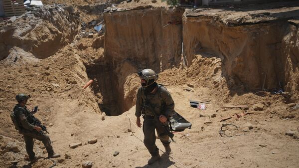 Israeli soldiers stand next to an entrance of a tunnel under the European Hospital in Khan Younis in southern Gaza, where the Israeli military claims that Hamas militants operated, on Sunday, June 8, 2025. ( - Sputnik International