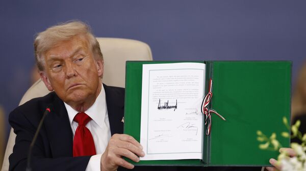 President Donald Trump shows a signed document during the signature ceremony at the Gaza International Peace Summit, in Sharm el-Sheikh, Egypt, Monday, Oct.13 2025. - Sputnik International