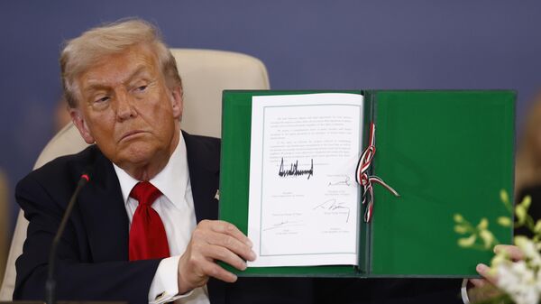 President Donald Trump shows a signed document during the signature ceremony at the Gaza International Peace Summit, in Sharm el-Sheikh, Egypt, Monday, Oct.13 2025. - Sputnik International