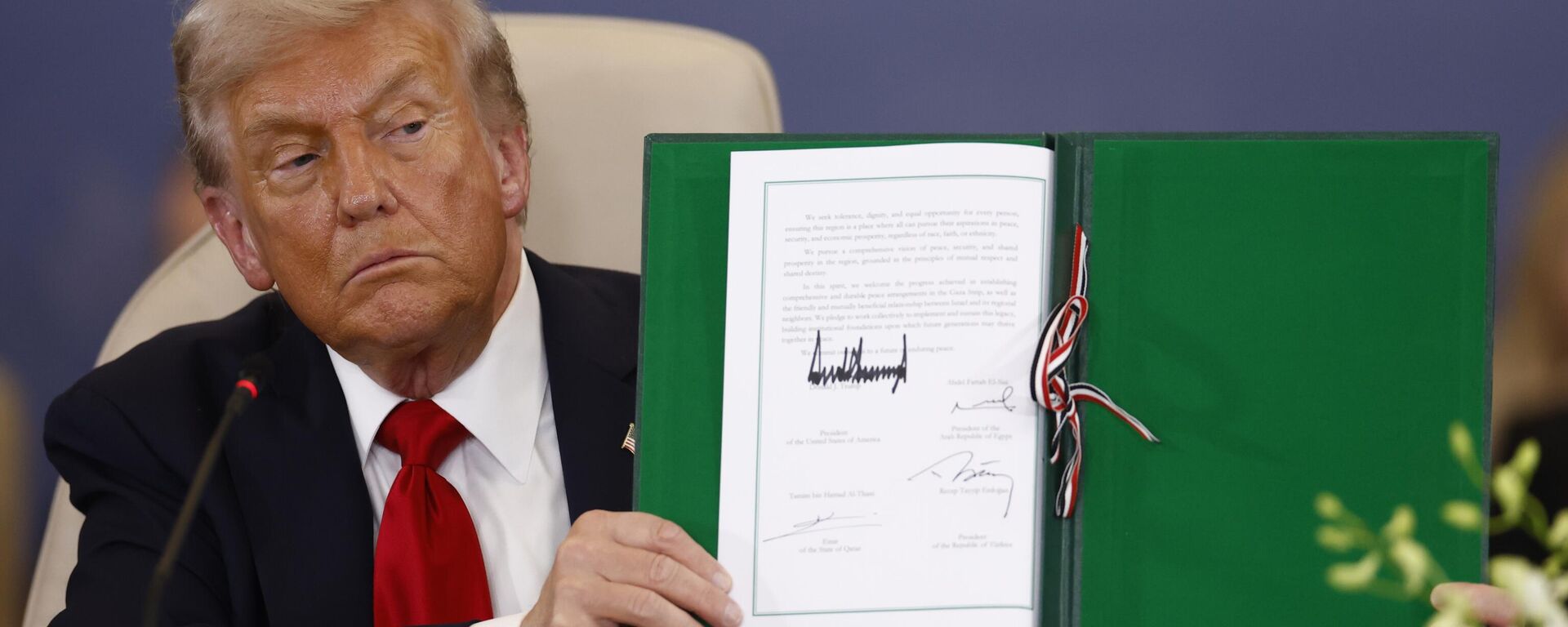 President Donald Trump shows a signed document during the signature ceremony at the Gaza International Peace Summit, in Sharm el-Sheikh, Egypt, Monday, Oct.13 2025. - Sputnik International, 1920, 13.10.2025