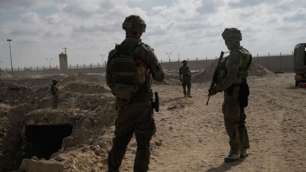 Israeli soldiers take up positions next to an entrance of a tunnel which the military says Hamas militants used in the southern Gaza Strip. - Sputnik International