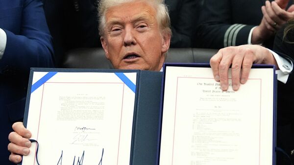 President Donald Trump displays the signed the funding bill to reopen the government, in the Oval Office of the White House, Wednesday, Nov. 12, 2025, in Washington.  - Sputnik International