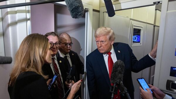 President Donald Trump leans in to hear a question as he speaks with reporters while in flight on Air Force One from Joint Base Andrews to his Mar-a-Lago estate in Palm Beach, Fla., Tuesday, Nov. 25, 2025 - Sputnik International