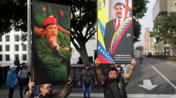 Government supporters display posters of Venezuelan President Nicolás Maduro, right, and former President Hugo Chávez in downtown Caracas, Venezuela, Saturday, Jan. 3, 2026. - Sputnik International