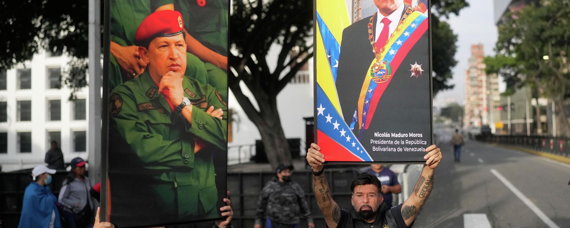 Government supporters display posters of Venezuelan President Nicolás Maduro, right, and former President Hugo Chávez in downtown Caracas, Venezuela, Saturday, Jan. 3, 2026. - Sputnik International, 1920, 03.01.2026