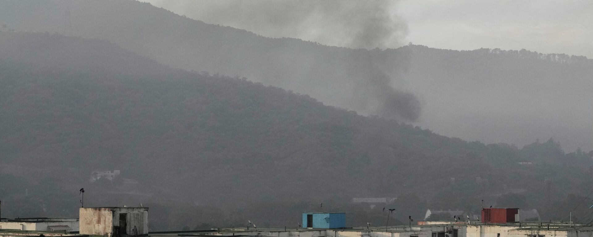 Smoke rises from Fort Tiuna, the main military garrison in Caracas, Venezuela, after multiple explosions were heard and aircraft swept through the area, Saturday, Jan. 3, 2026.  - Sputnik International, 1920, 05.01.2026