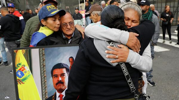 Supporters of Venezuelan President Nicolás Maduro embrace in downtown Caracas, Venezuela, Saturday, Jan. 3, 2026 - Sputnik International
