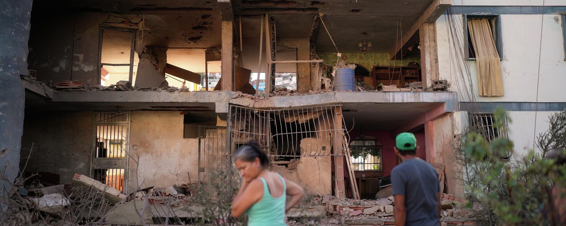 Residents look at a damaged apartment complex that neighbors say was hit during US strikes to capture Venezuelan President Nicolás Maduro, in Catia La Mar, Venezuela, Sunday, Jan. 4, 2026.  - Sputnik International, 1920, 05.01.2026