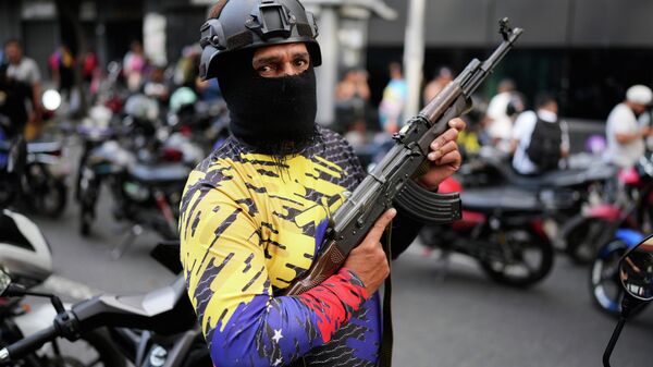 An armed civilian takes part in a pro-government protest demanding the release of President Nicolas Maduro and first lady Cilia Flores, a day after U.S. forces captured and flew them to the United States, in Caracas, Venezuela, Sunday, Jan. 4, 2026.   - Sputnik International