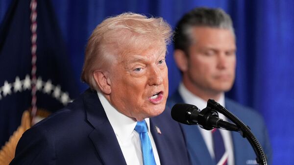 President Donald Trump speaks at his Mar-a-Lago club, Saturday, Jan. 3, 2026, in Palm Beach, Fla., as Defense Secretary Pete Hegseth listens - Sputnik International