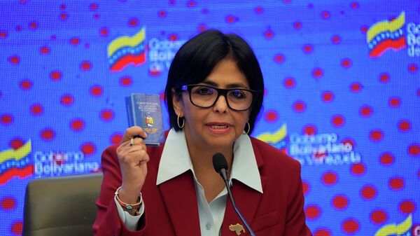 Acting President Delcy Rodriguez holds up a copy of the Venezuela National Constitution - Sputnik International