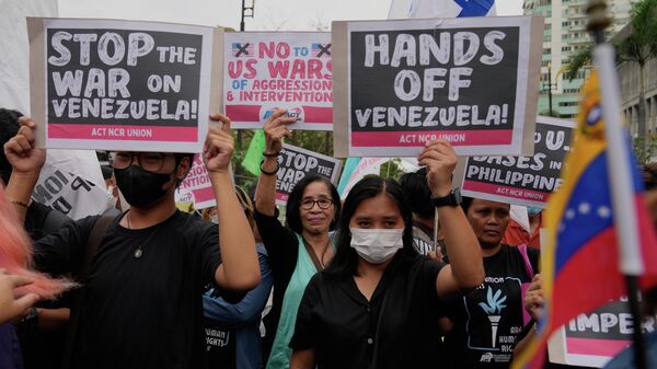 Protesters hold slogans as they denounce the US government after the US captured Venezuelan President Nicolas Maduro during a rally near the US Embassy in Manila, Philippines on Monday, Jan. 5, 2026. - Sputnik International