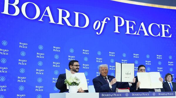 President Donald Trump, center, holds up a signed Board of Peace charter during the Annual Meeting of the World Economic Forum in Davos, Switzerland, Thursday, Jan. 22, 2026.  - Sputnik International