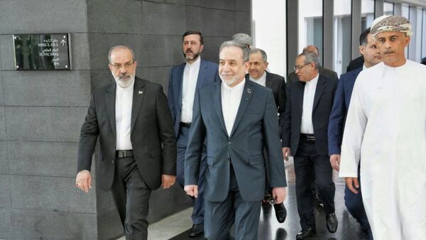 In this photo released by the Iranian Foreign Ministry, Iranian Foreign Minister Abbas Araghchi, center, heads to venue for talks between Iran and the U.S., in Muscat, Oman, Friday, Feb. 6, 2026.  - Sputnik International