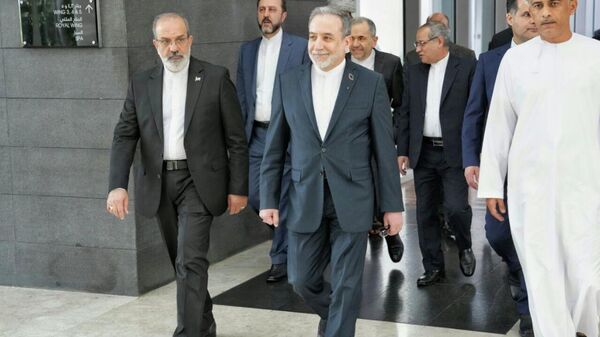 In this photo released by the Iranian Foreign Ministry, Iranian Foreign Minister Abbas Araghchi, center, heads to venue for talks between Iran and the U.S., in Muscat, Oman, Friday, Feb. 6, 2026.  - Sputnik International