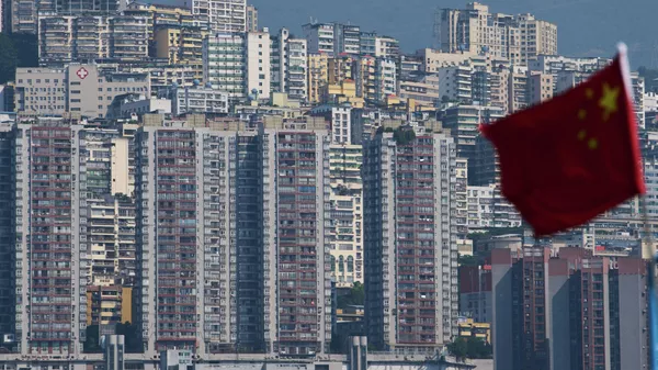 A Chinese national flag flutters against the high-rise residential buildings in Wushan county, in southwest China's Chongqing Municipality - Sputnik International