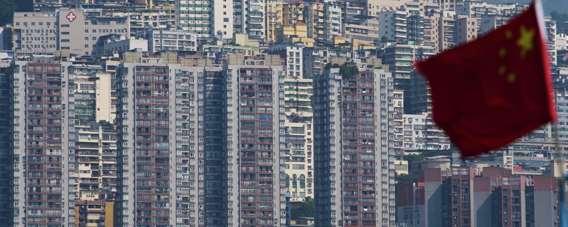 A Chinese national flag flutters against the high-rise residential buildings in Wushan county, in southwest China's Chongqing Municipality - Sputnik International, 1920, 12.02.2026