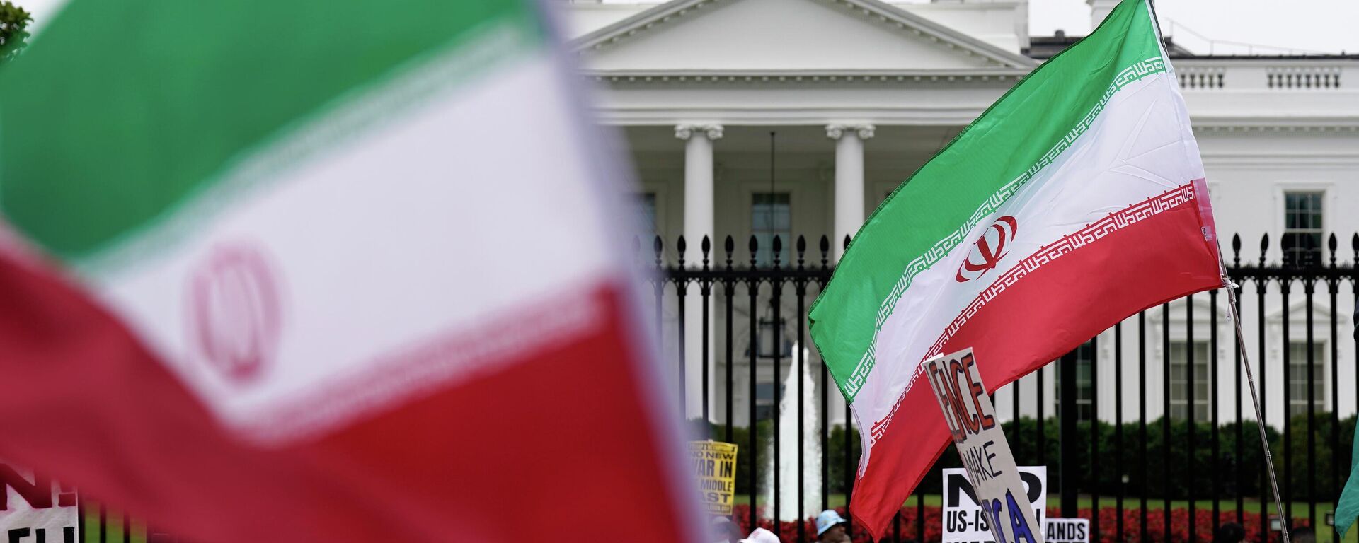 Demonstrators carry signs and wave the Iranian flag as they rally outside the White House, Sunday, June 22, 2025, in Washington, to protest the U.S. military strike on three sites in Iran early Sunday.  - Sputnik International, 1920, 07.05.2026
