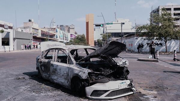 A vehicle sits charred after being set on fire, on a road in Guadalajara, Jalisco state, Mexico, Sunday, Feb. 22, 2026, after the death of the leader of the Jalisco New Generation Cartel, Nemesio Rubén Oseguera Cervantes, known asEl Mencho. - Sputnik International