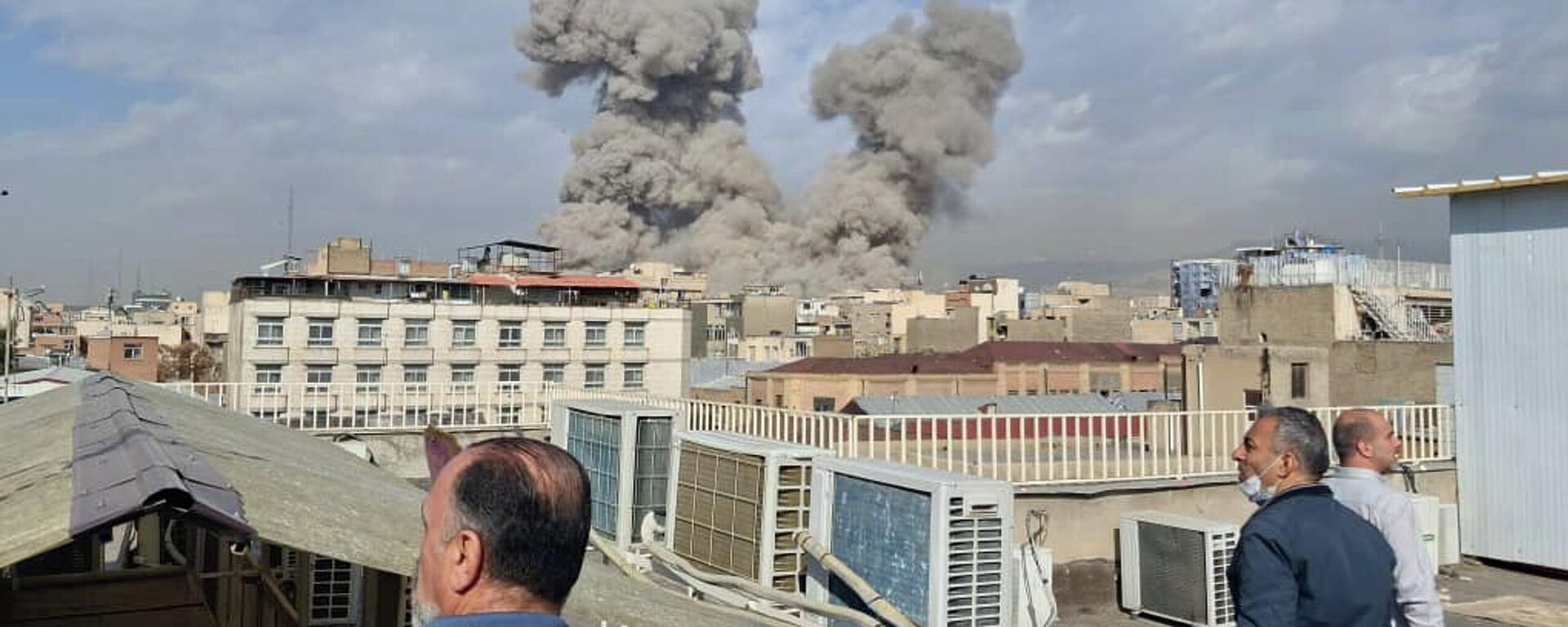 People watch as smoke rises on the skyline after an explosion in Tehran, Iran, Saturday, Feb. 28, 2026. - Sputnik International, 1920, 01.03.2026