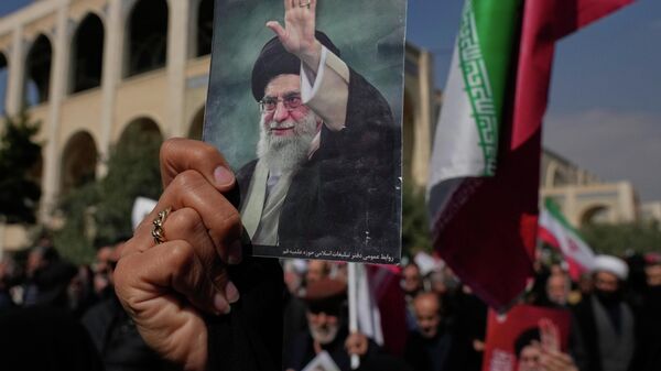 A woman holds up a picture of the late Iranian Supreme Leader Ayatollah Ali Khamenei as government supporters march against the ongoing U.S.-Israeli military campaign after Friday prayers at the Imam Khomeini Grand mosque in Tehran, Iran, Friday, March 6, 2026. (AP Photo/Vahid Salemi) - Sputnik International