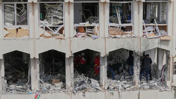 Security officers check the damage at a building struck by an Israeli airstrike in the southern port city of Sidon, Lebanon, Friday, March 6, 2026. (AP Photo/Mohammed Zaatari) - Sputnik International