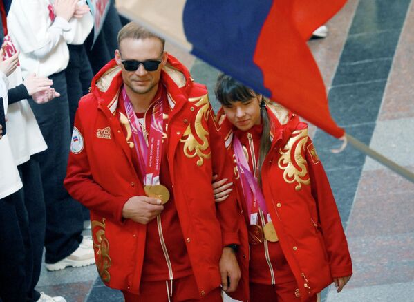 Three-time Olympic champion Anastasiia Bagiian and her leading athlete, Sergey Sinyakin, during the honoring of Russian athletes at GUM. - Sputnik International