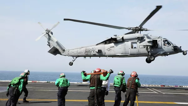 In this March 20, 2017 photograph, an MH-60 helicopter takes off from the USS George H.W. Bush as it travels toward the Strait of Hormuz.  - Sputnik International