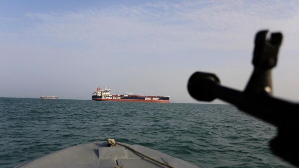 In this Sunday, July 21, 2019 photo, a speedboat of Iran's Revolutionary Guard trains a weapon toward the British-flagged oil tanker Stena Impero, which was seized in the Strait of Hormuz on Friday by the Guard, in the Iranian port of Bandar Abbas. Global stock markets were subdued Monday while the price of oil climbed as tensions in the Persian Gulf escalated after Iran's seizure of a British oil tanker on Friday.  - Sputnik International