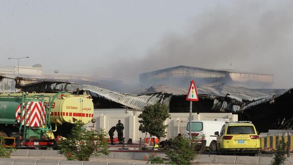 Firefighters work as smoke rises outside a damaged warehouse in an industrial area in Al Rayyan, Qatar, following an Iranian strike, Sunday, March 1, 2026. (AP Photo) - Sputnik International