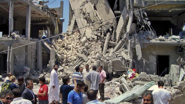 In a June 19, 2011, file photo made on a government-organized tour, members of the media and others examine the remains of a damaged residential building in Tripoli, Libya. - Sputnik International