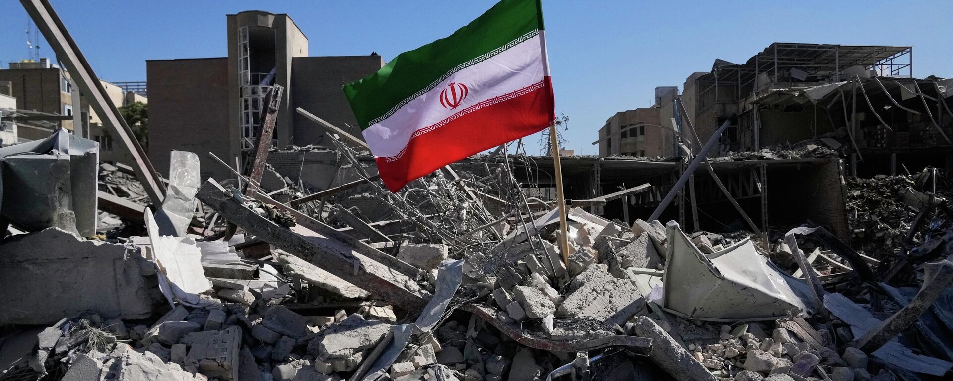 An Iranian flag is placed among the ruins of a police station struck Monday during the U.S.–Israeli military campaign in Tehran, Iran, Tuesday, March 3, 2026. (AP Photo/Vahid Salemi) - Sputnik International, 1920, 26.03.2026
