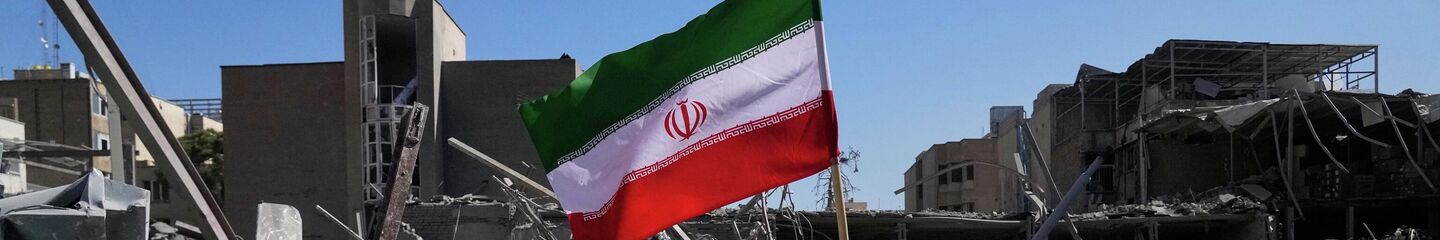 An Iranian flag is placed among the ruins of a police station struck Monday during the U.S.–Israeli military campaign in Tehran, Iran, Tuesday, March 3, 2026. (AP Photo/Vahid Salemi) - Sputnik International