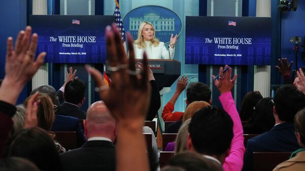 Reporters raise their hands to ask questions as White House press secretary Karoline Leavitt speaks with reporters in the James Brady Press Briefing Room at the White House, Wednesday, March 25, 2026, in Washington.  - Sputnik International