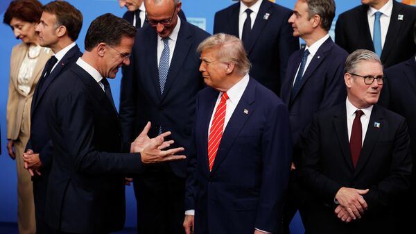President Donald Trump, center, speaks with NATO Secretary General Mark Rutte, left, during a group photo of NATO heads of state and government at the NATO summit in The Hague, Netherlands, Wednesday, June 25, 2025. - Sputnik International