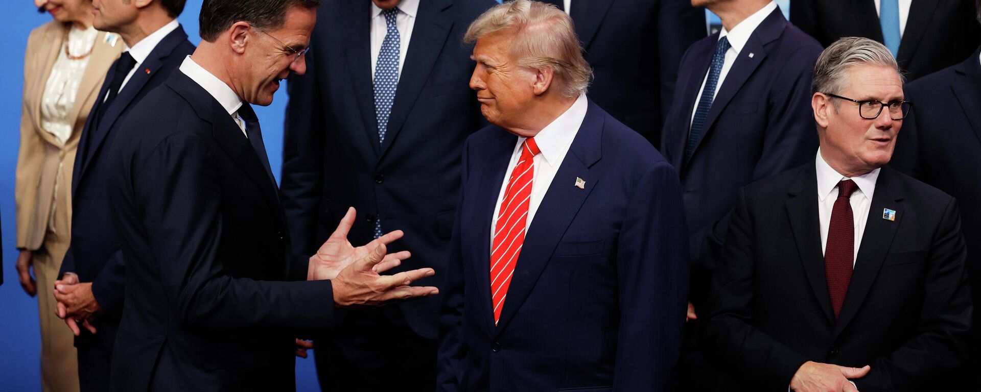 President Donald Trump, center, speaks with NATO Secretary General Mark Rutte, left, during a group photo of NATO heads of state and government at the NATO summit in The Hague, Netherlands, Wednesday, June 25, 2025. - Sputnik International, 1920, 28.03.2026