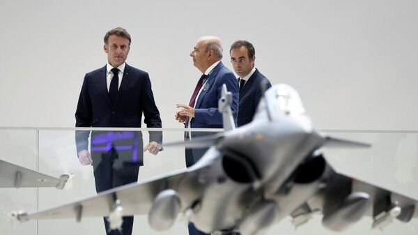 French President Emmanuel Macron looks at a display model of a Rafale fighter jet - Sputnik International