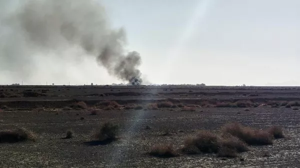 In this image provided by Sepahnews, the Iranian Revolutionary Guard's official website, black smoke rises into the air at what Iran's state TV claimed was the site where an American transport plane and two helicopters involved in a rescue operation were shot down, in Isfahan province, Iran, April, 2026. - Sputnik International