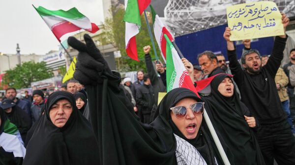 Iranians chant slogans after the announcement of a two-week ceasefire with the United States and Israel in Tehran, Iran, Wednesday, April 8, 2026. (AP Photo/Francisco Seco) - Sputnik International