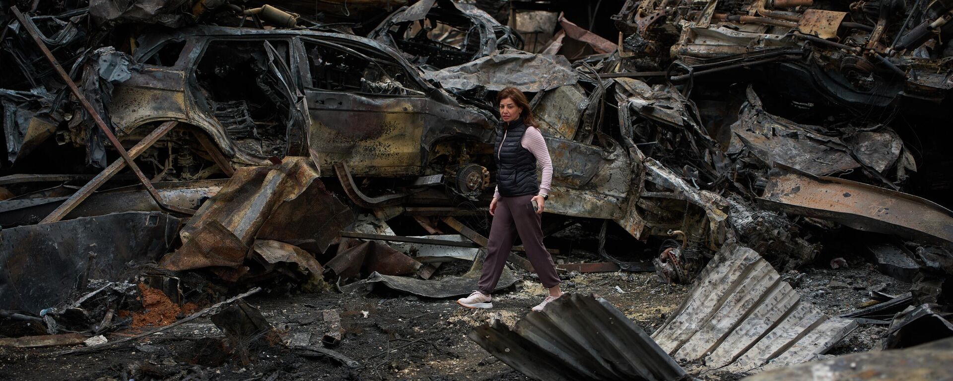 A resident walks near charred cars, at the site of Wednesday's Israeli airstrike, in Beirut, Lebanon, Friday, April 10, 2026. - Sputnik International, 1920, 11.04.2026