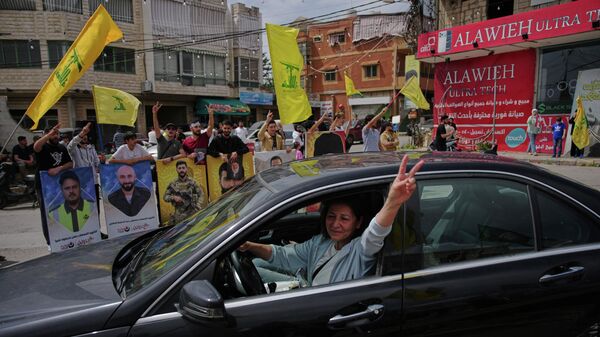 People holding Hezbollah flags celebrate as displaced residents return to their villages following a ceasefire between Israel and Hezbollah, in Zefta, southern Lebanon, Friday, April 17, 2026. - Sputnik International
