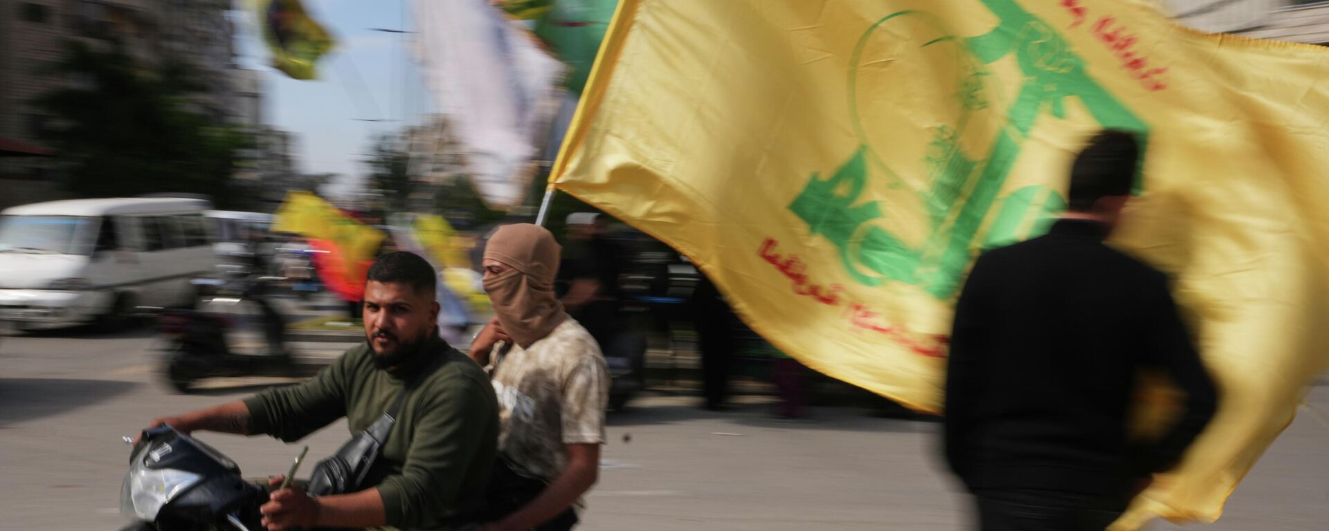 Men ride a scooter while waving a Hezbollah flag during a small gathering in Dahiyeh, Beirut's southern suburbs, Lebanon, Saturday, April 25, 2026. - Sputnik International, 1920, 28.04.2026