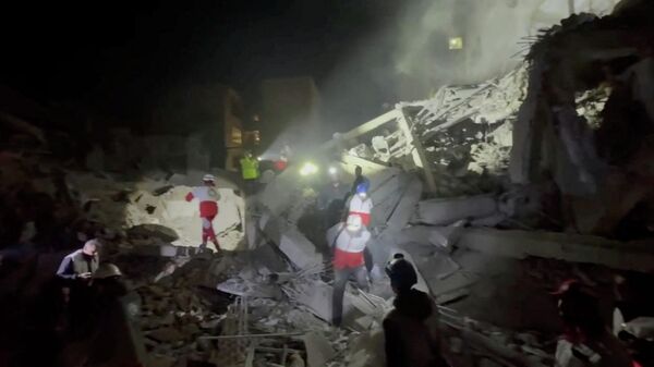 Emergency personnel and other people gather at the site of a damaged synagogue, following what Iran’s semi-official Mehr news agency said was a U.S.-Israeli projectile, amid the U.S.-Israeli conflict with Iran, in Tehran, Iran, in this screen grab taken from a handout video released on April 7, 2026. I - Sputnik International