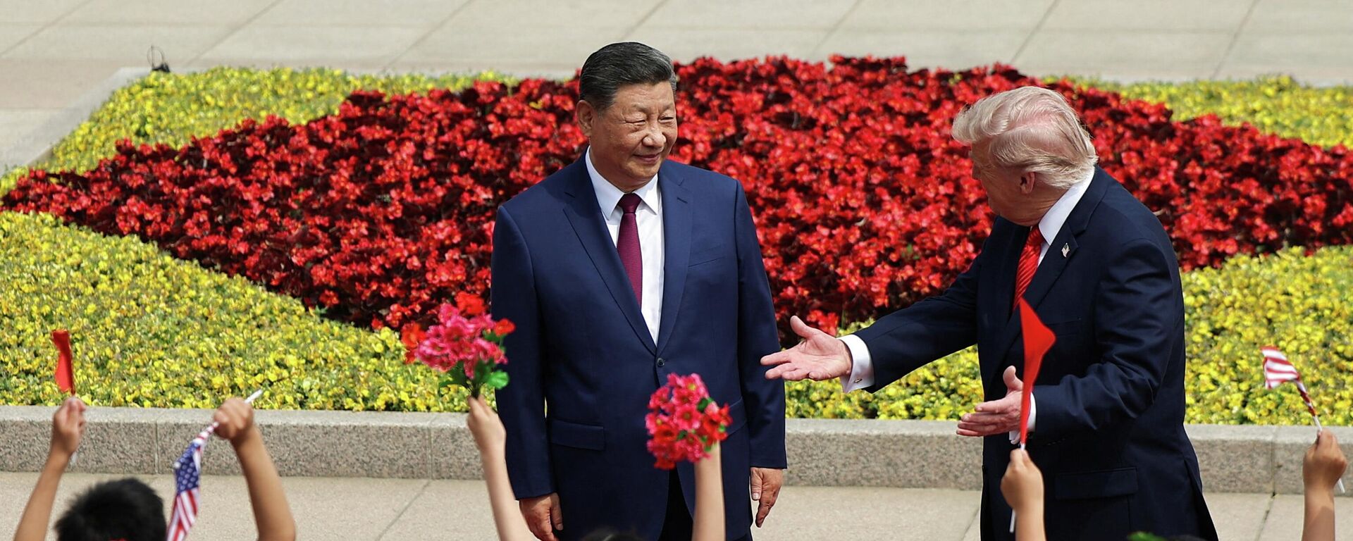 Children hold Chinese and U.S. flags, as U.S. President Donald Trump participates in a welcome ceremony with Chinese President Xi Jinping at the Great Hall of the People in Beijing, China, May 14, 2026.  - Sputnik International, 1920, 14.05.2026