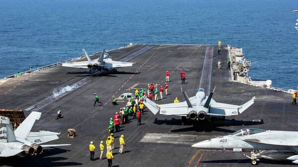 This image provided by US Central Command shows a F/A-18E Super Hornet launching at left, as an F/A-18E Super at right, prepares to launch from the flight deck of Nimitz-class aircraft carrier USS Abraham Lincoln (CVN 72) in support of Operation Epic Fury, on Saturday, Feb. 28, 2026 - Sputnik International