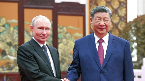 Russian President Vladimir Putin and Chinese President Xi Jinping drink tea during a meeting at the Great Hall of the People in Beijing. - Sputnik International