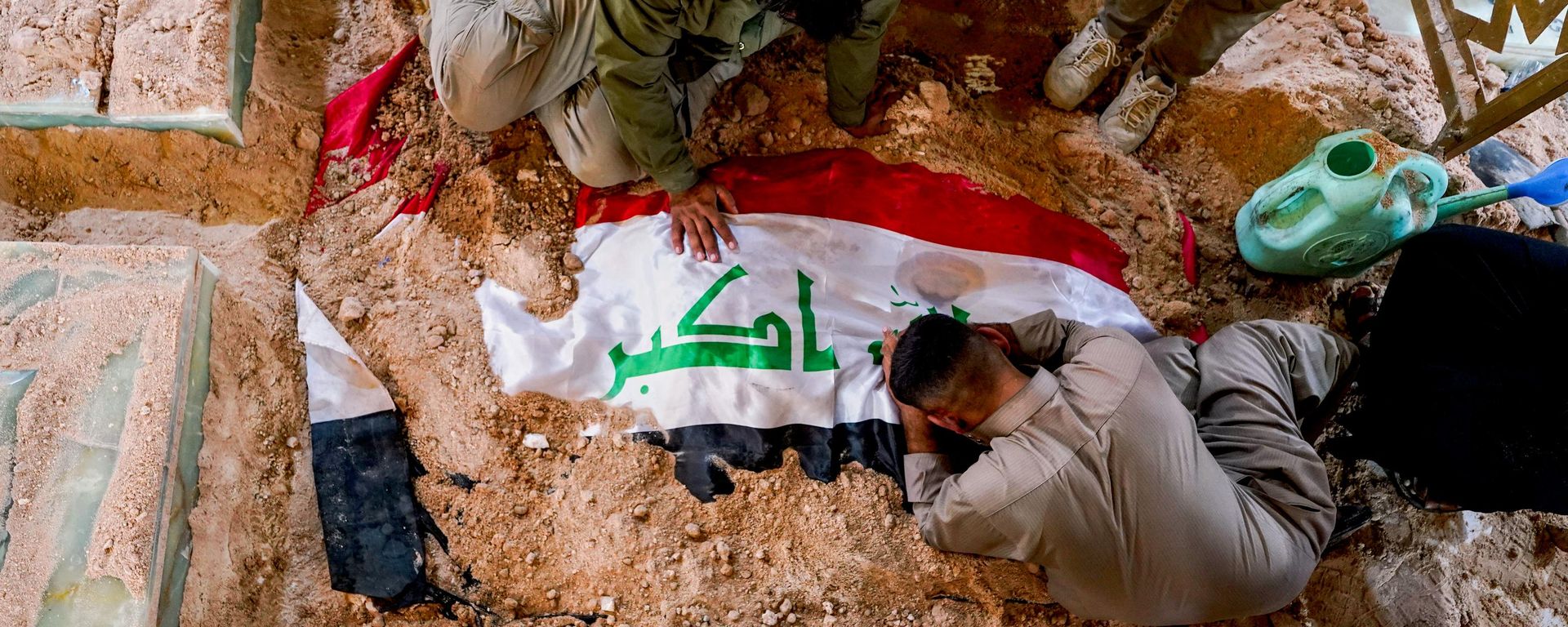 Mourners grieve at the grave of a Popular Mobilization Forces fighter during a funeral for fighters killed in airstrikes on PMF bases in Najaf, Iraq, Thursday, July 30, 2026. - Sputnik International, 1920, 29.07.2026