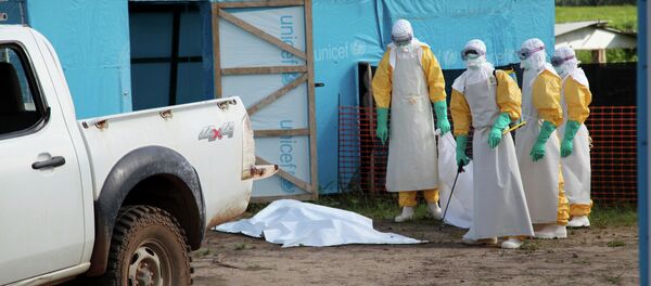 Medical workers by an isolation tent housing those infected with Ebola, Liberia. - Sputnik International