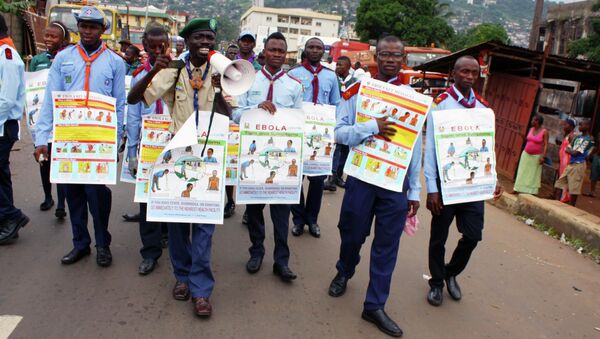 UNICEF members are holding posters detailing Ebola virus symptoms, Freetown, Sierra Leone. - Sputnik International